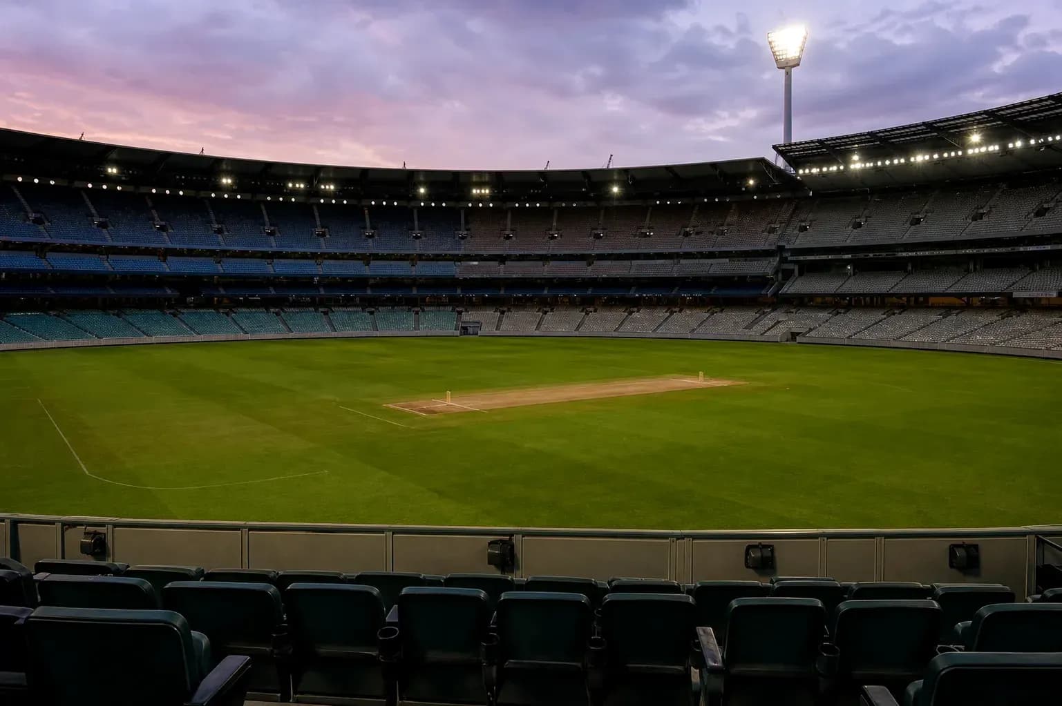 Empty cricket stadium with pitch and seating Empty cricket stadium with pitch and seating