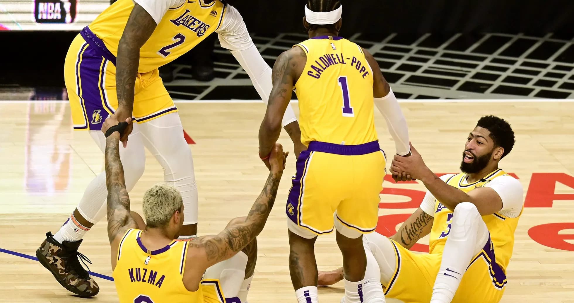 Lakers players helping teammates up from the court Lakers players helping teammates up from the court