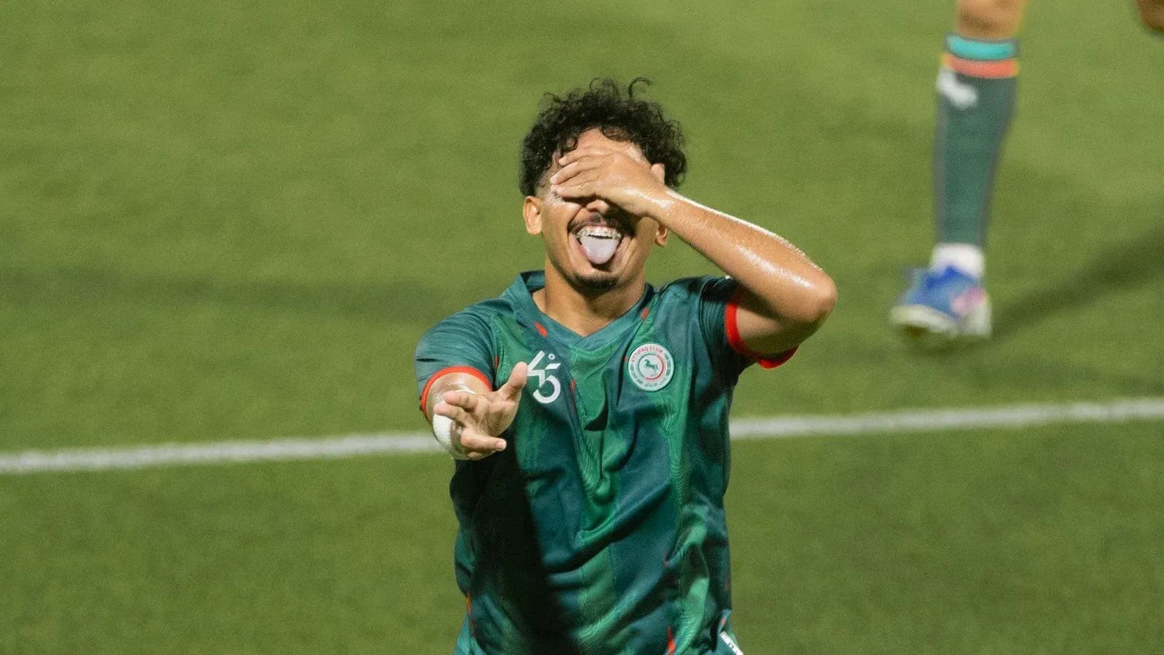Player celebrating with playful gesture on field Player celebrating with playful gesture on field