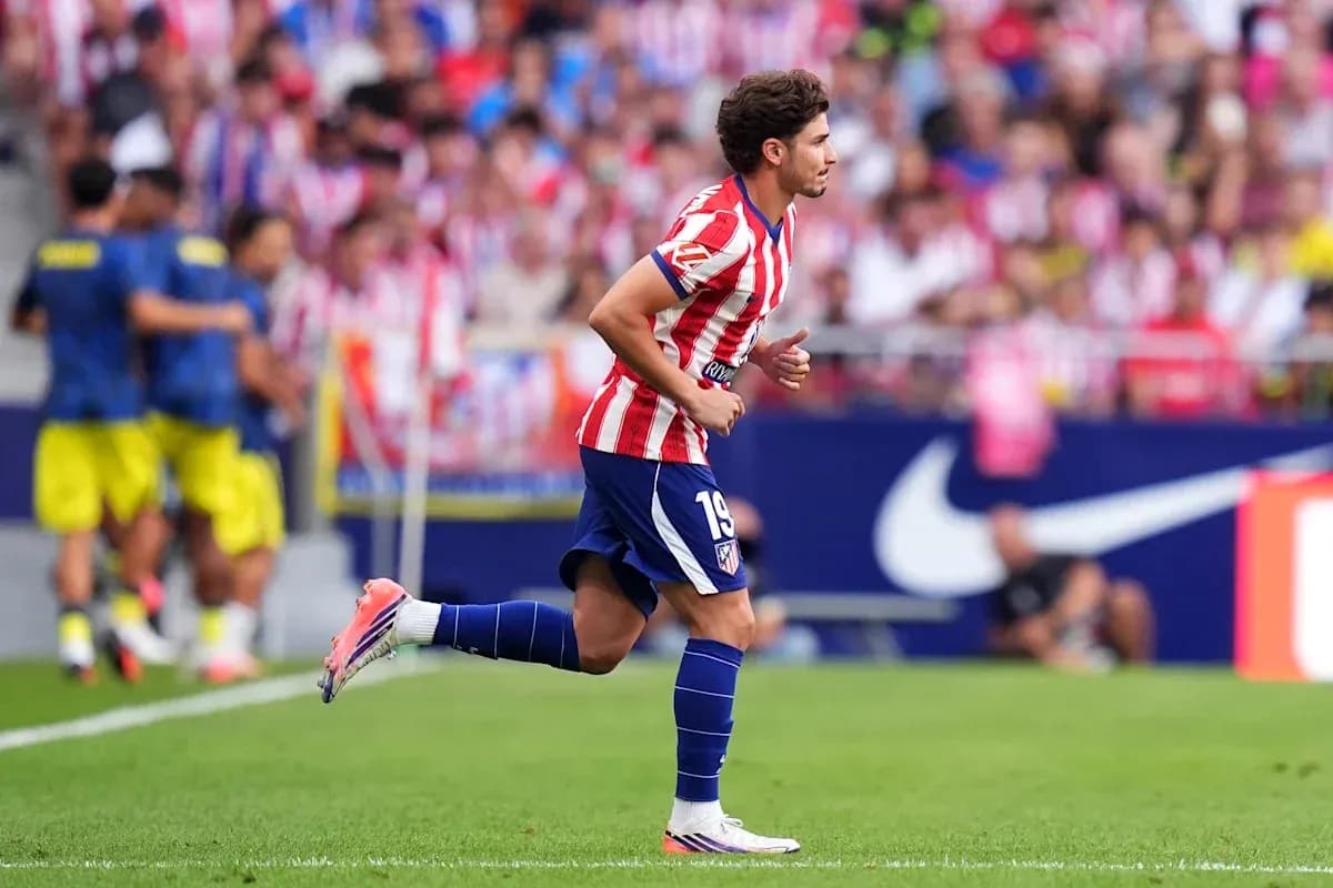 Player in Atletico Madrid kit running on pitch Player in Atletico Madrid kit running on pitch