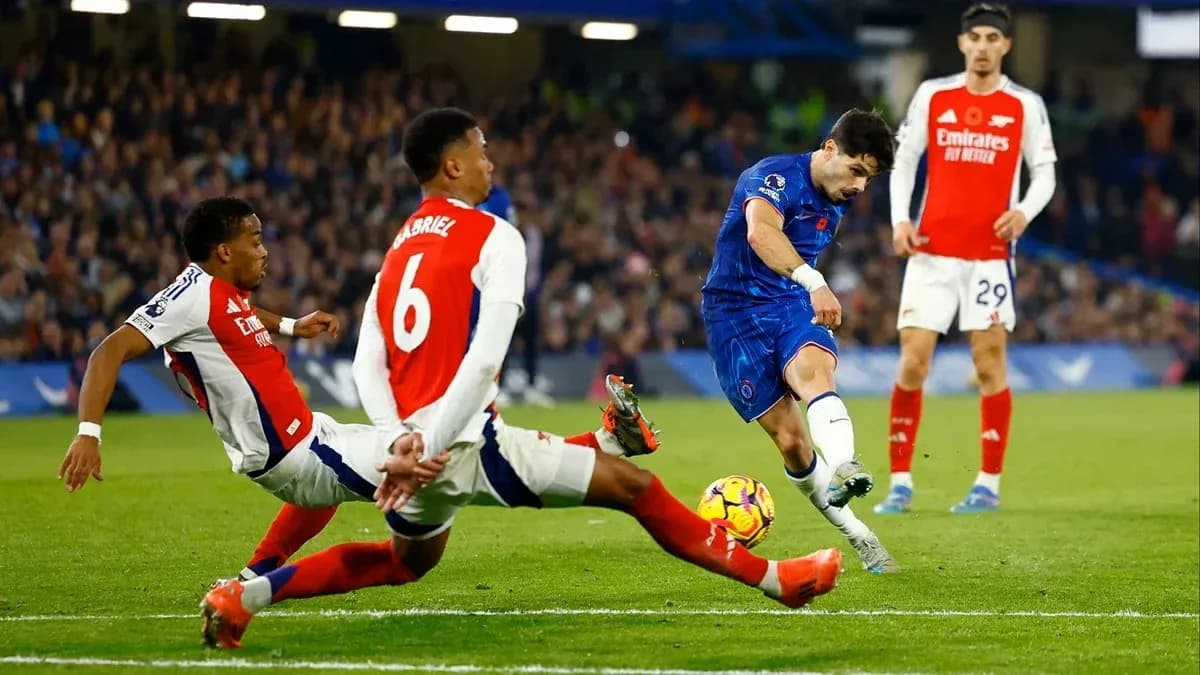 Chelsea player shooting while two Arsenal defenders challenge Chelsea player shooting while two Arsenal defenders challenge