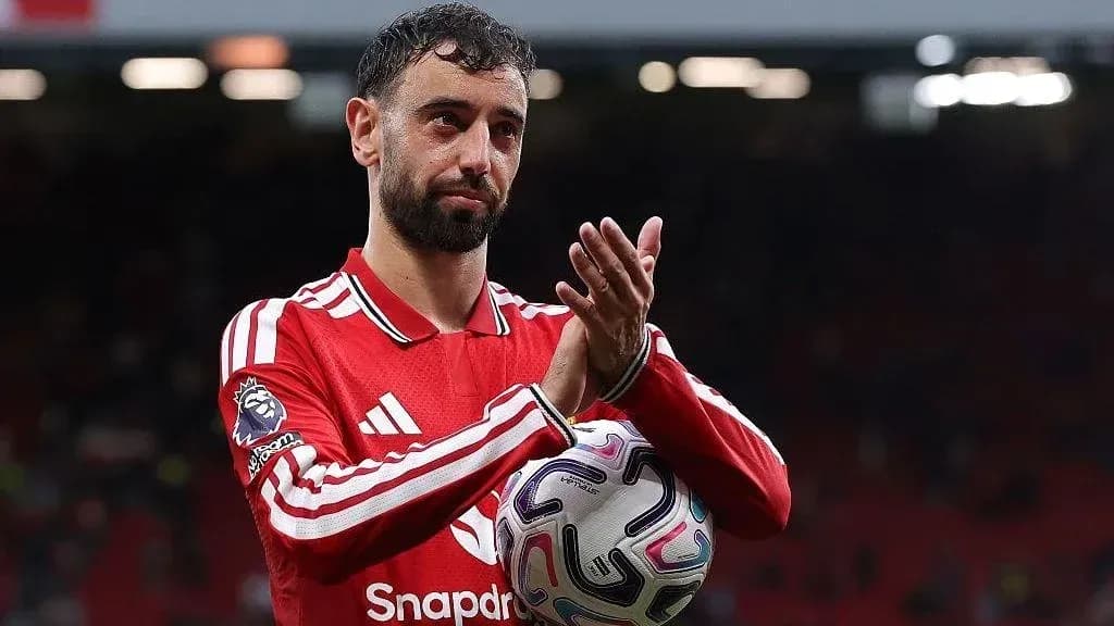 Player applauding fans while holding a football Player applauding fans while holding a football