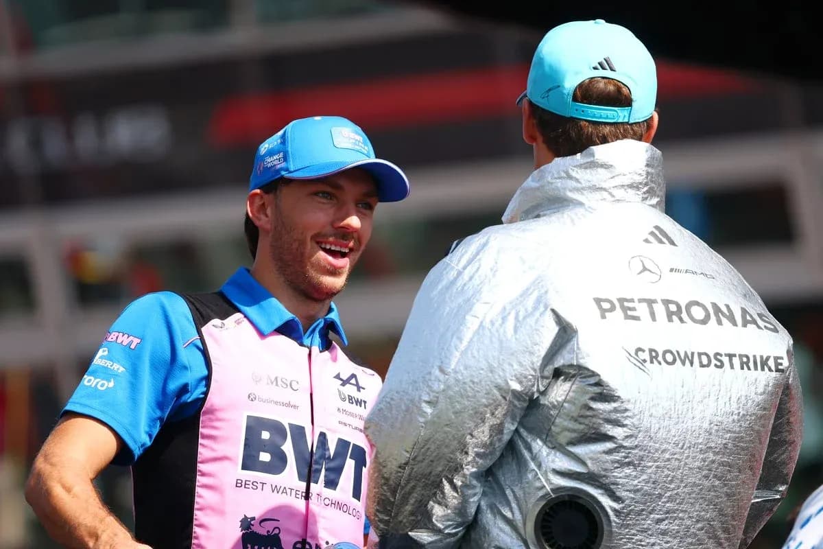 Two Formula 1 drivers conversing in team gear Two Formula 1 drivers conversing in team gear