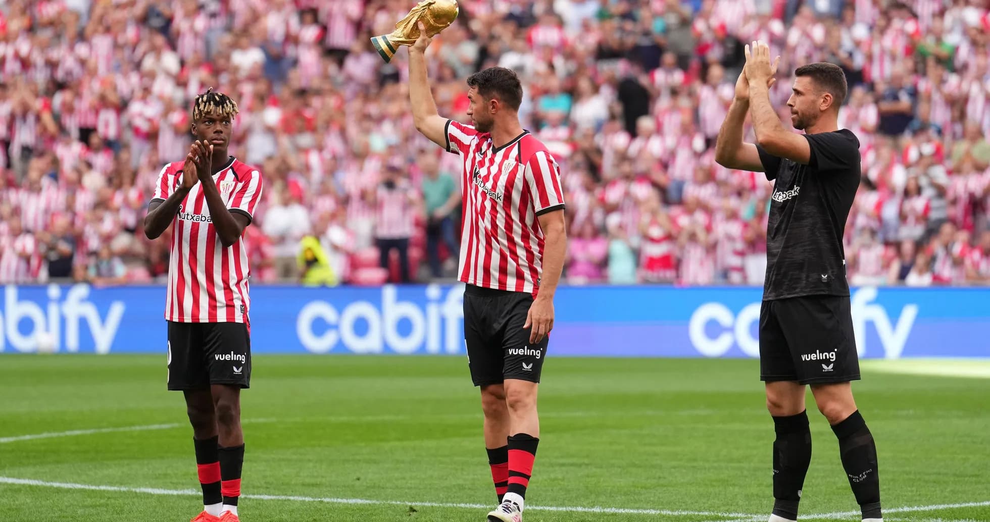 Players celebrating with a trophy in stadium Players celebrating with a trophy in stadium