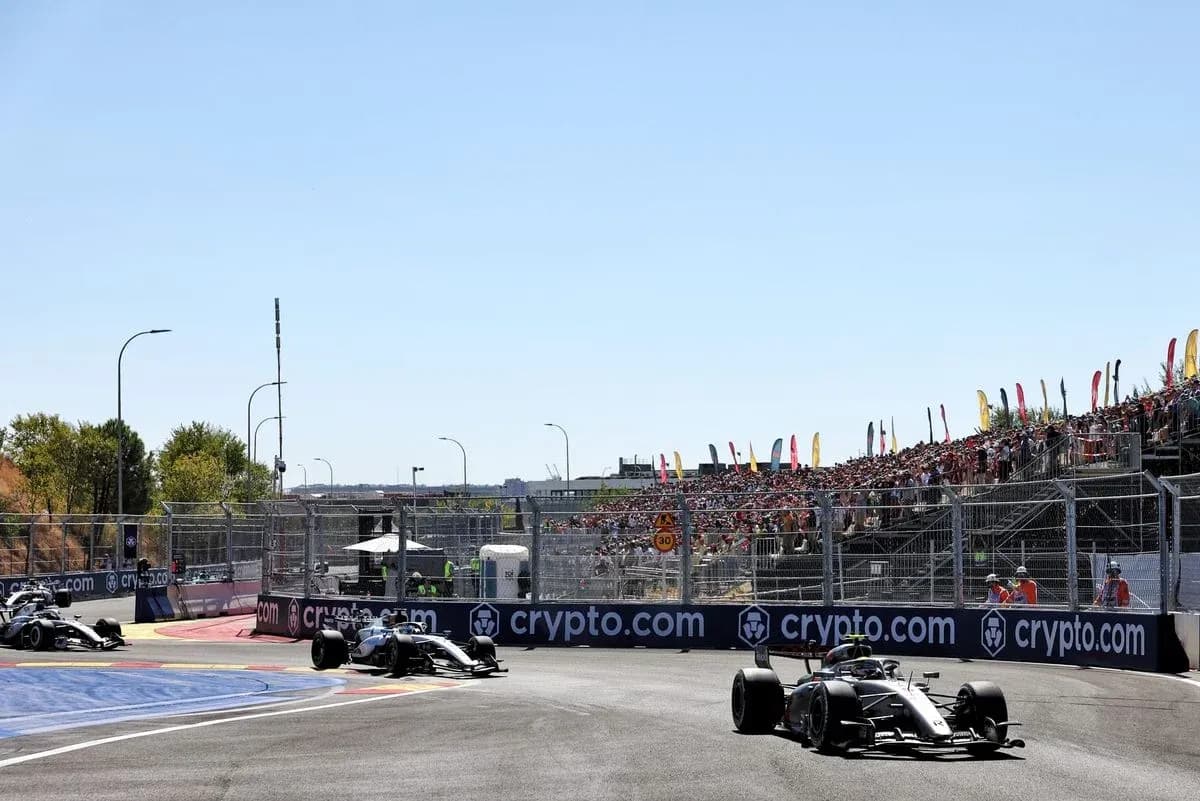 Formula 1 cars racing at a crowded circuit Formula 1 cars racing at a crowded circuit