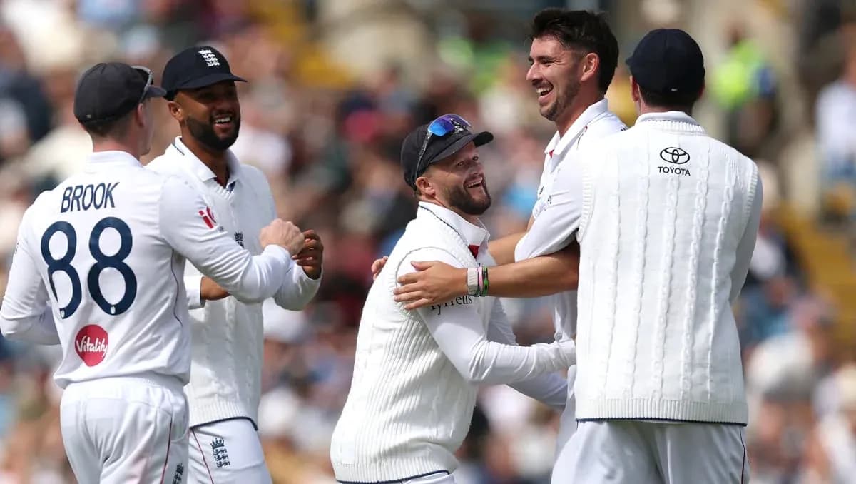England cricket players celebrating a wicket on field England cricket players celebrating a wicket on field