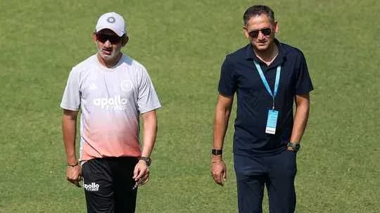 Two men walking on cricket field during practice Two men walking on cricket field during practice