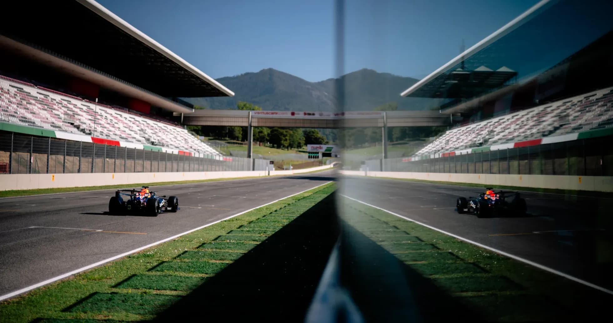 Race car on track with grandstands in background Race car on track with grandstands in background