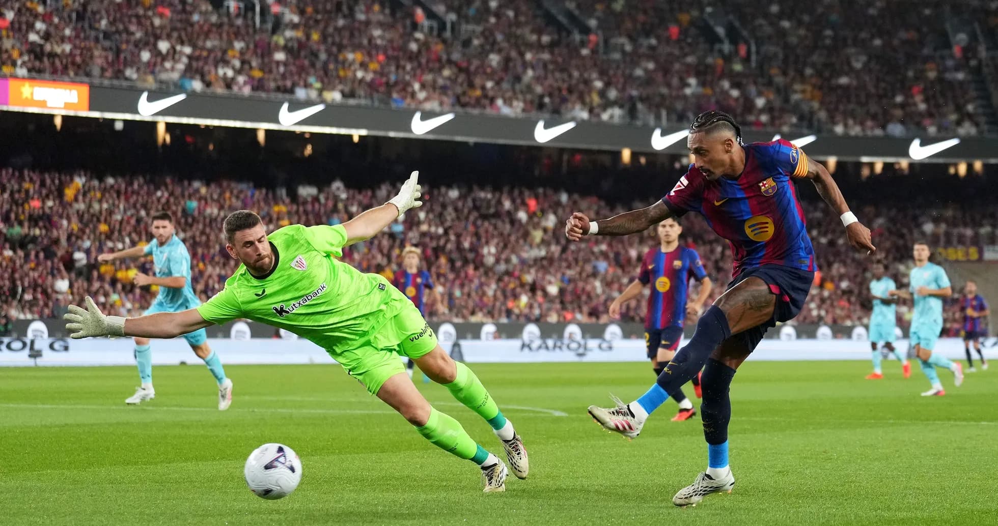 Barcelona player shooting past diving goalkeeper during match Barcelona player shooting past diving goalkeeper during match