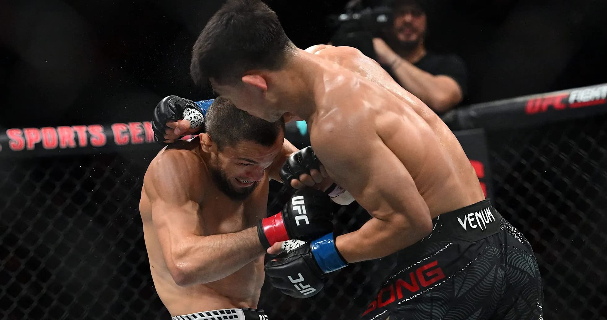 Two fighters engaged in close combat during match Two fighters engaged in close combat during match