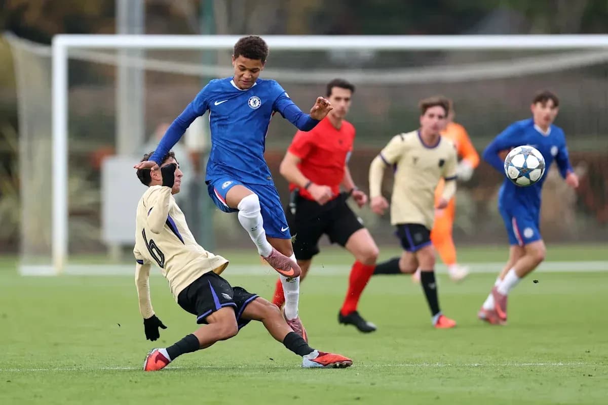 Player in blue evading tackle during youth football match Player in blue evading tackle during youth football match