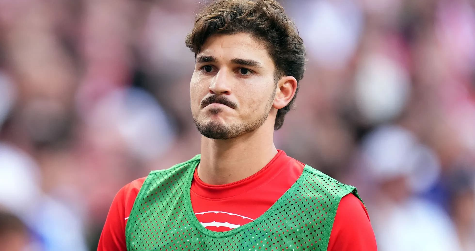 Player in green training bib on sideline Player in green training bib on sideline