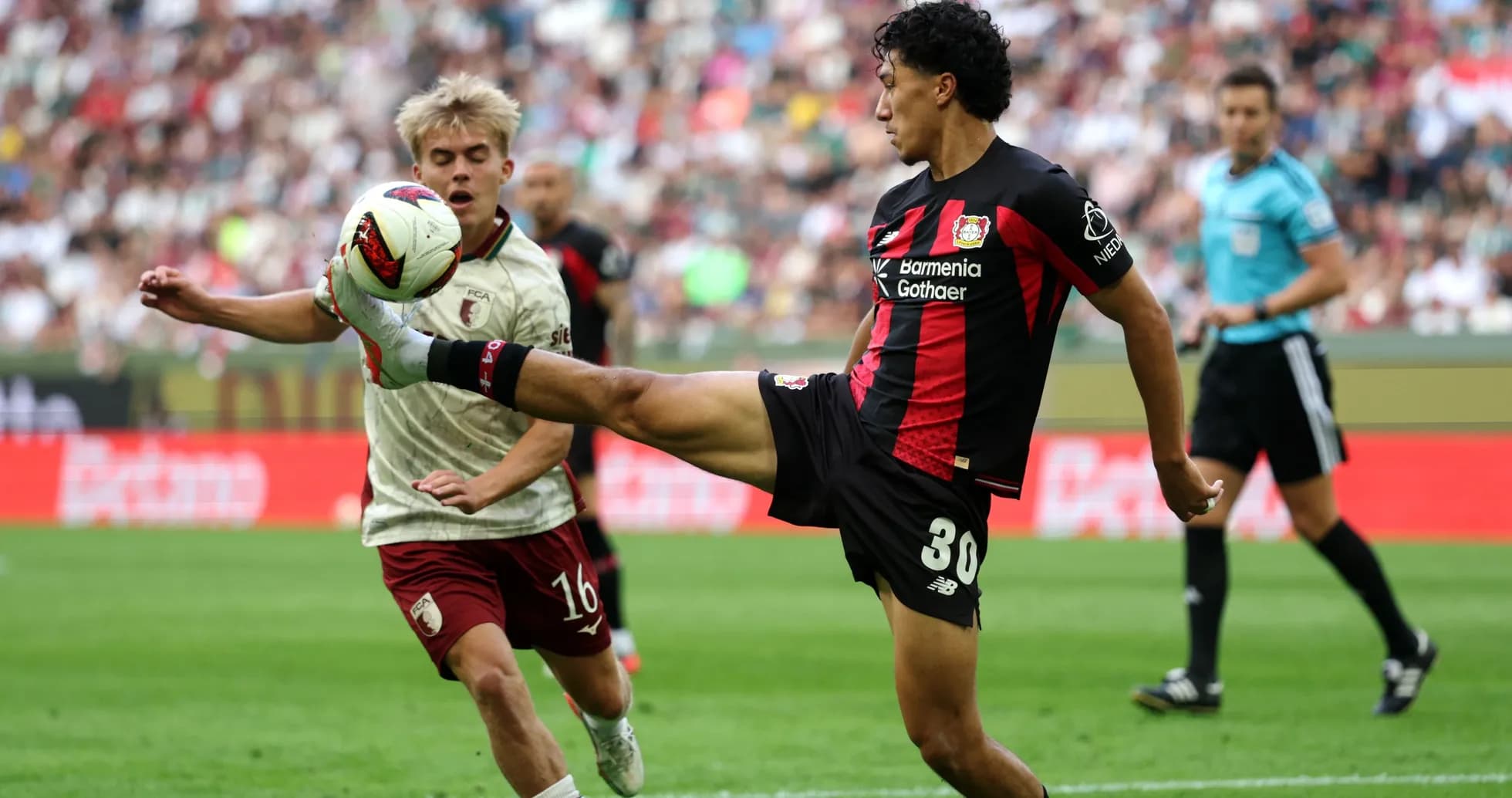 Player kicking ball while opponent attempts to block Player kicking ball while opponent attempts to block