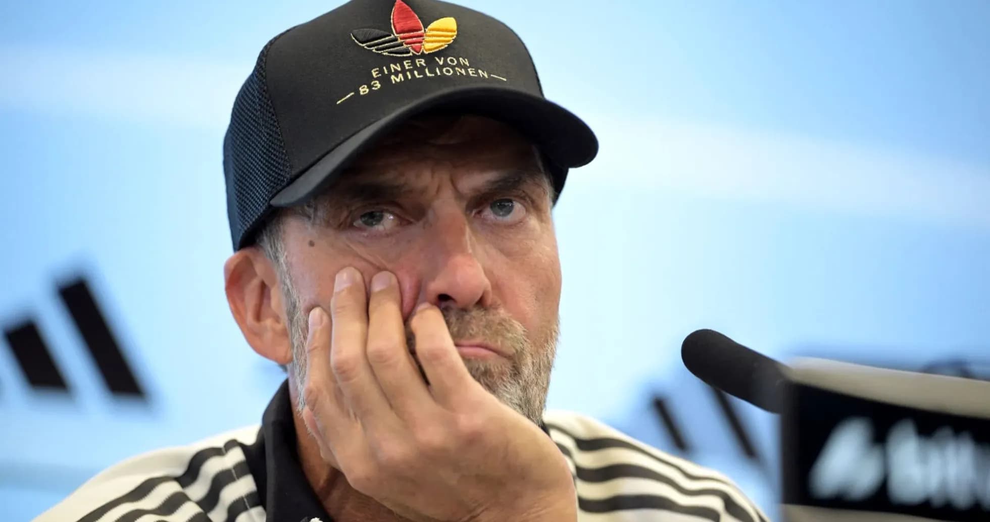 Manager at press conference with thoughtful expression Manager at press conference with thoughtful expression
