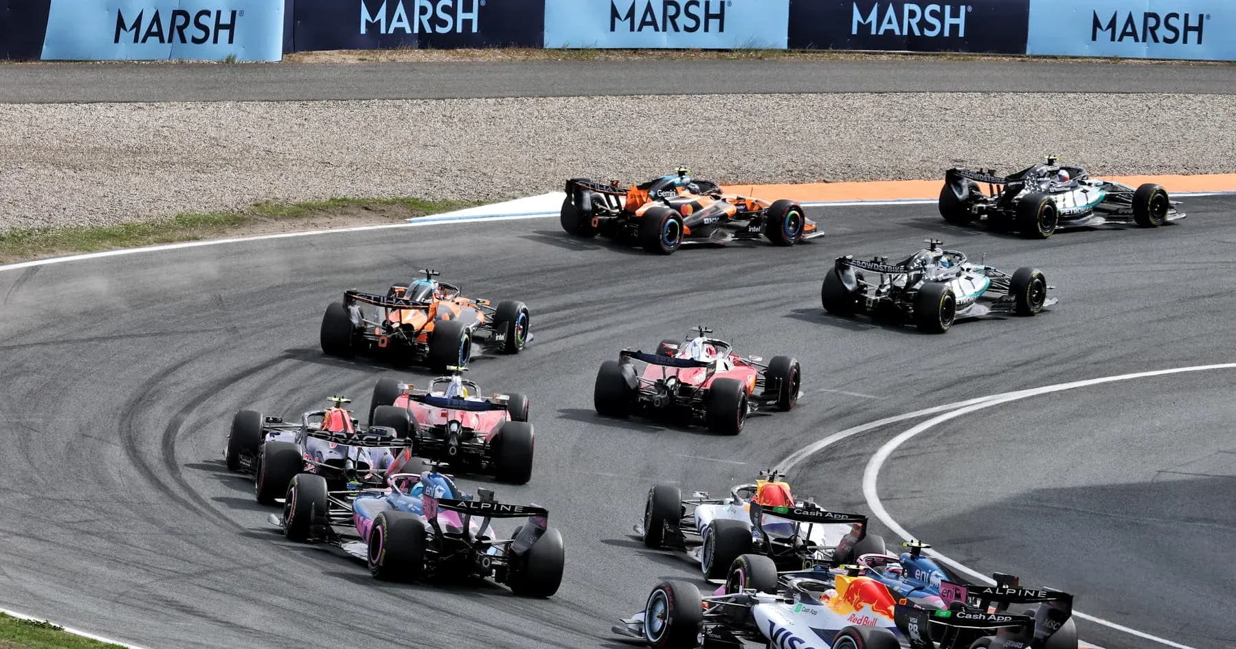 Multiple Formula 1 cars racing around a corner Multiple Formula 1 cars racing around a corner