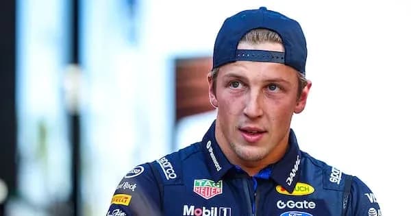 Race car driver wearing team uniform and cap Race car driver wearing team uniform and cap
