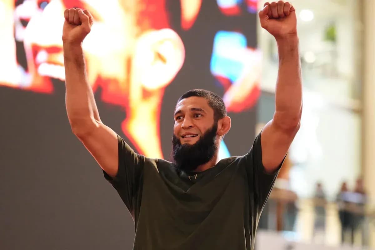 Fighter celebrating with raised arms at event Fighter celebrating with raised arms at event