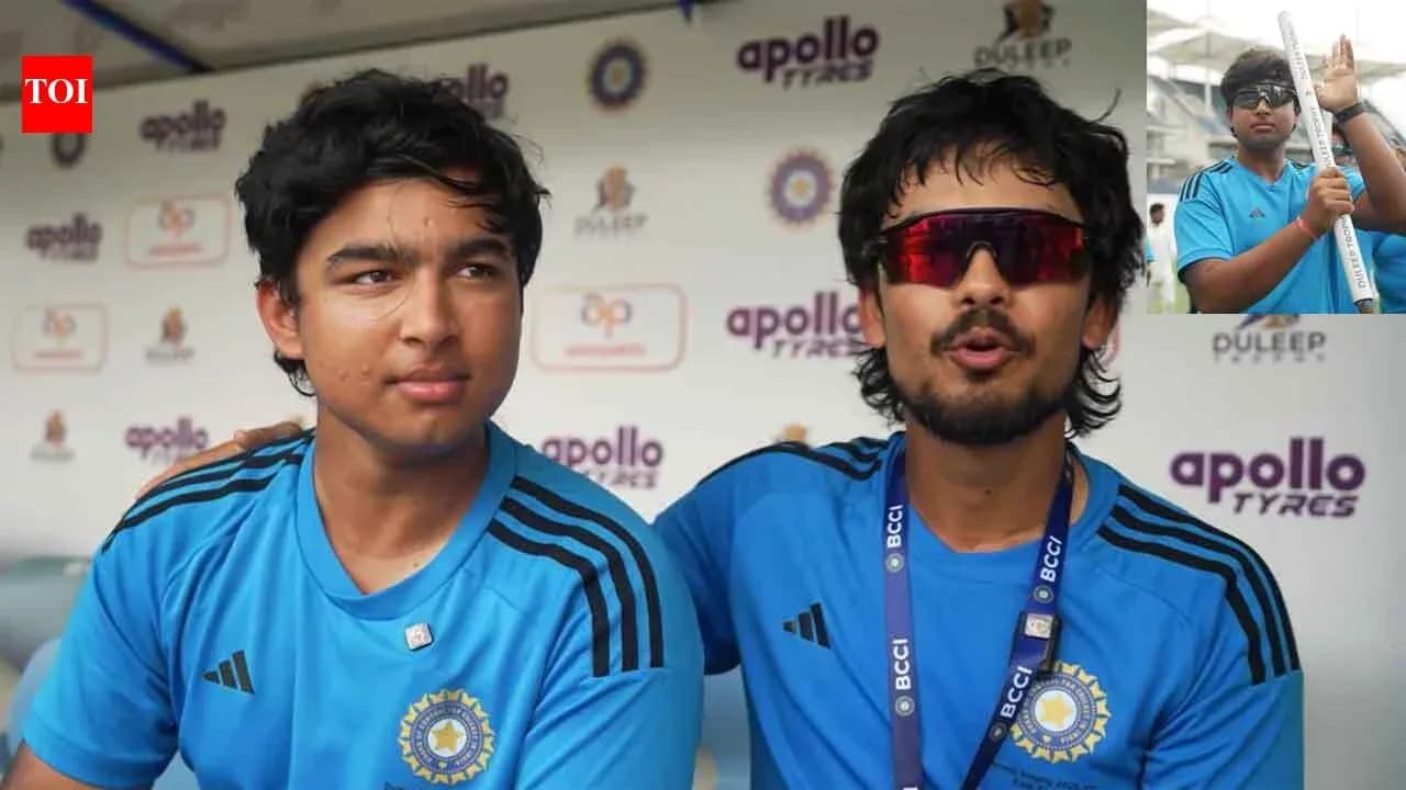 Two cricket players in blue jerseys at press conference Two cricket players in blue jerseys at press conference