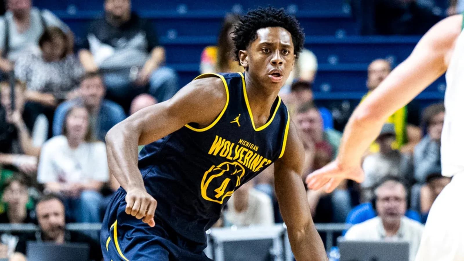 Player in Michigan Wolverines jersey on court Player in Michigan Wolverines jersey on court