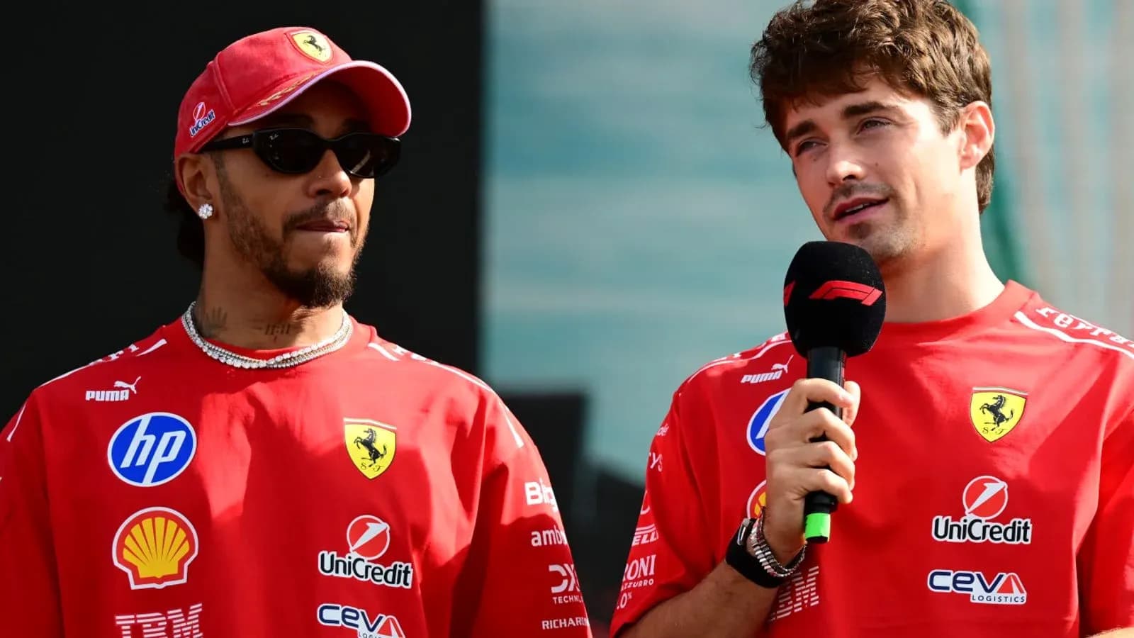 Two drivers in Ferrari shirts speaking at event Two drivers in Ferrari shirts speaking at event