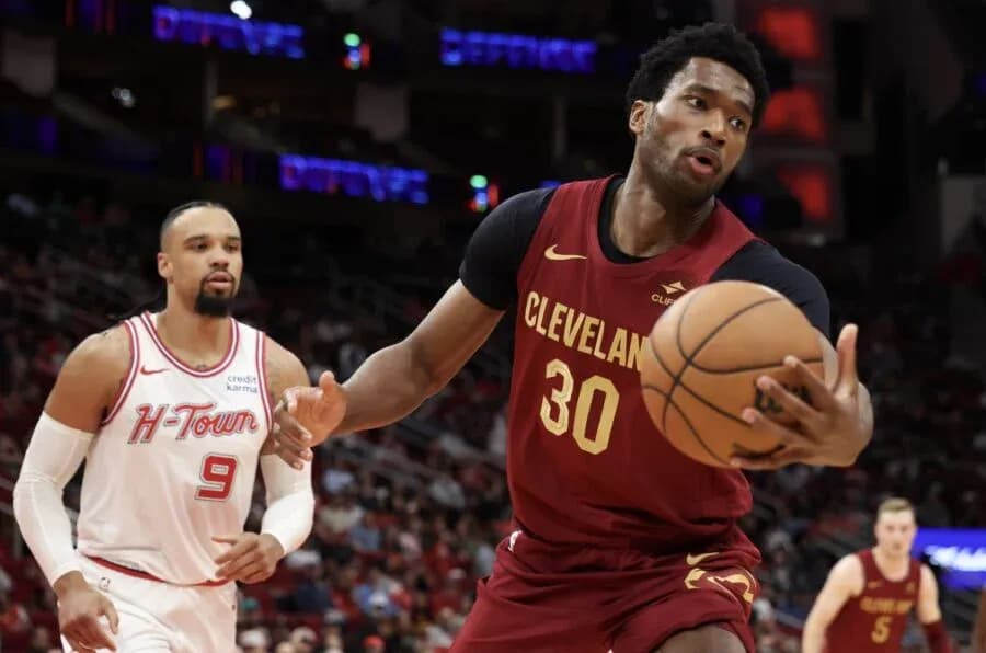 Cleveland player dribbling basketball past opponent Cleveland player dribbling basketball past opponent